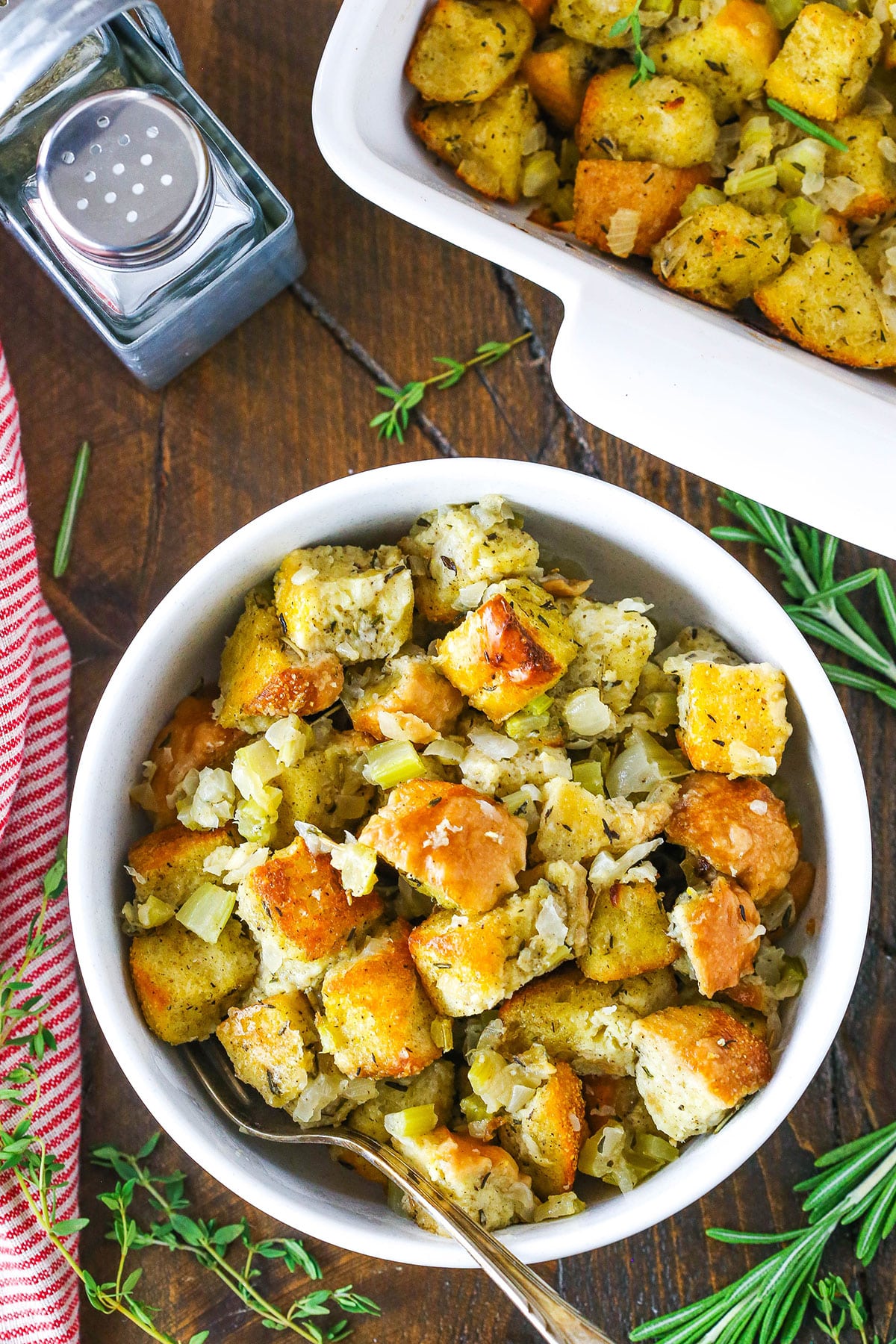 Classic homemade stuffing in a white bowl with a silver spoon.