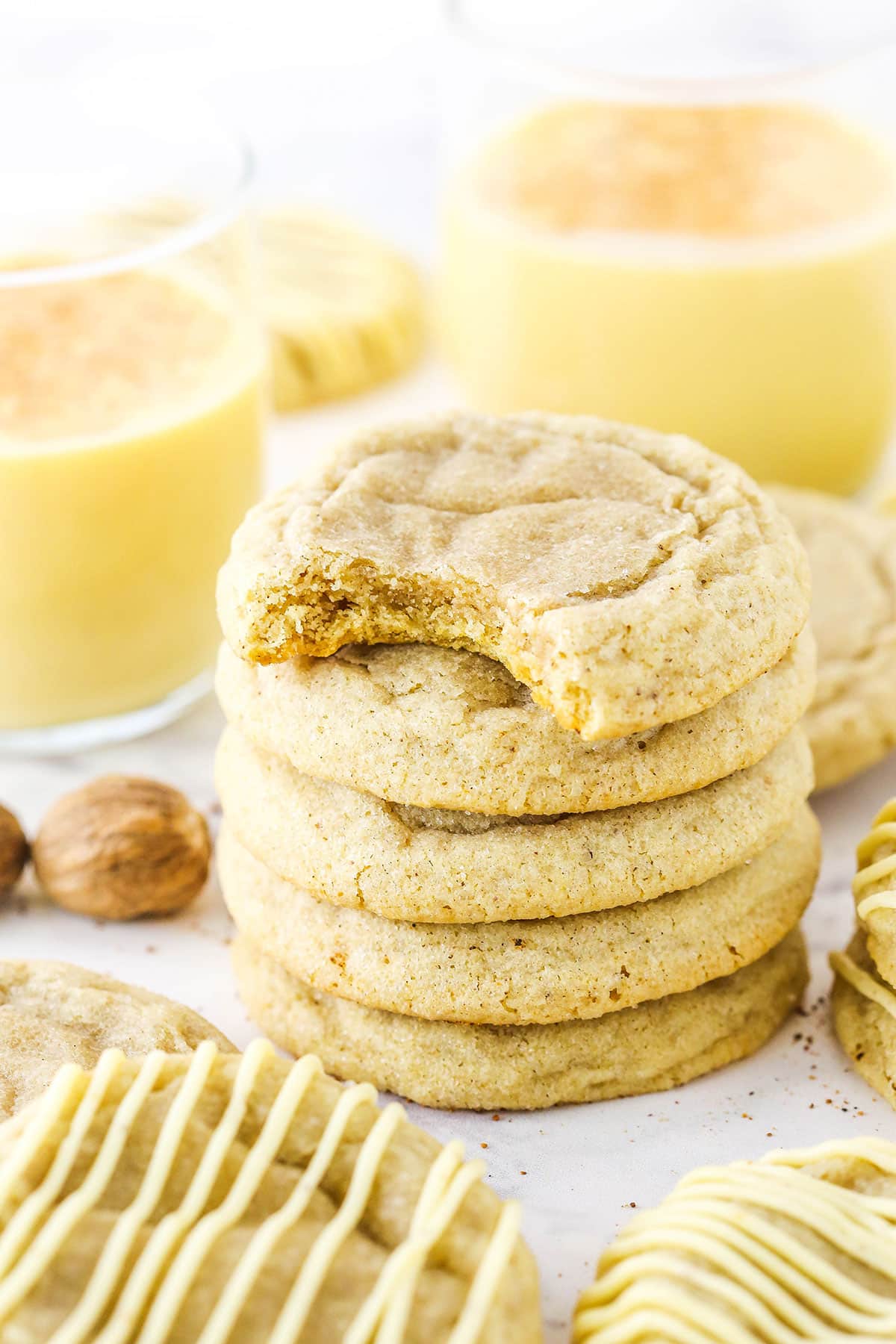 Five Eggnog Cookies stacked with the top cookie missing a bite