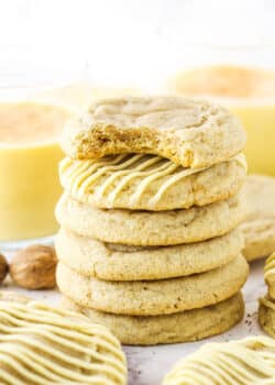 Six Eggnog Cookies stacked with the top cookie missing a bite.