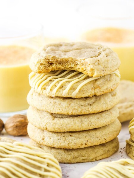 Six Eggnog Cookies stacked with the top cookie missing a bite.