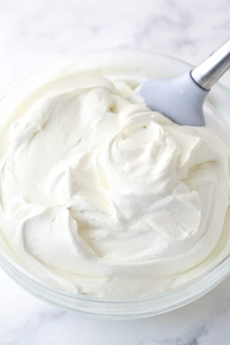Folding sweetened condensed milk into Cool Whip.