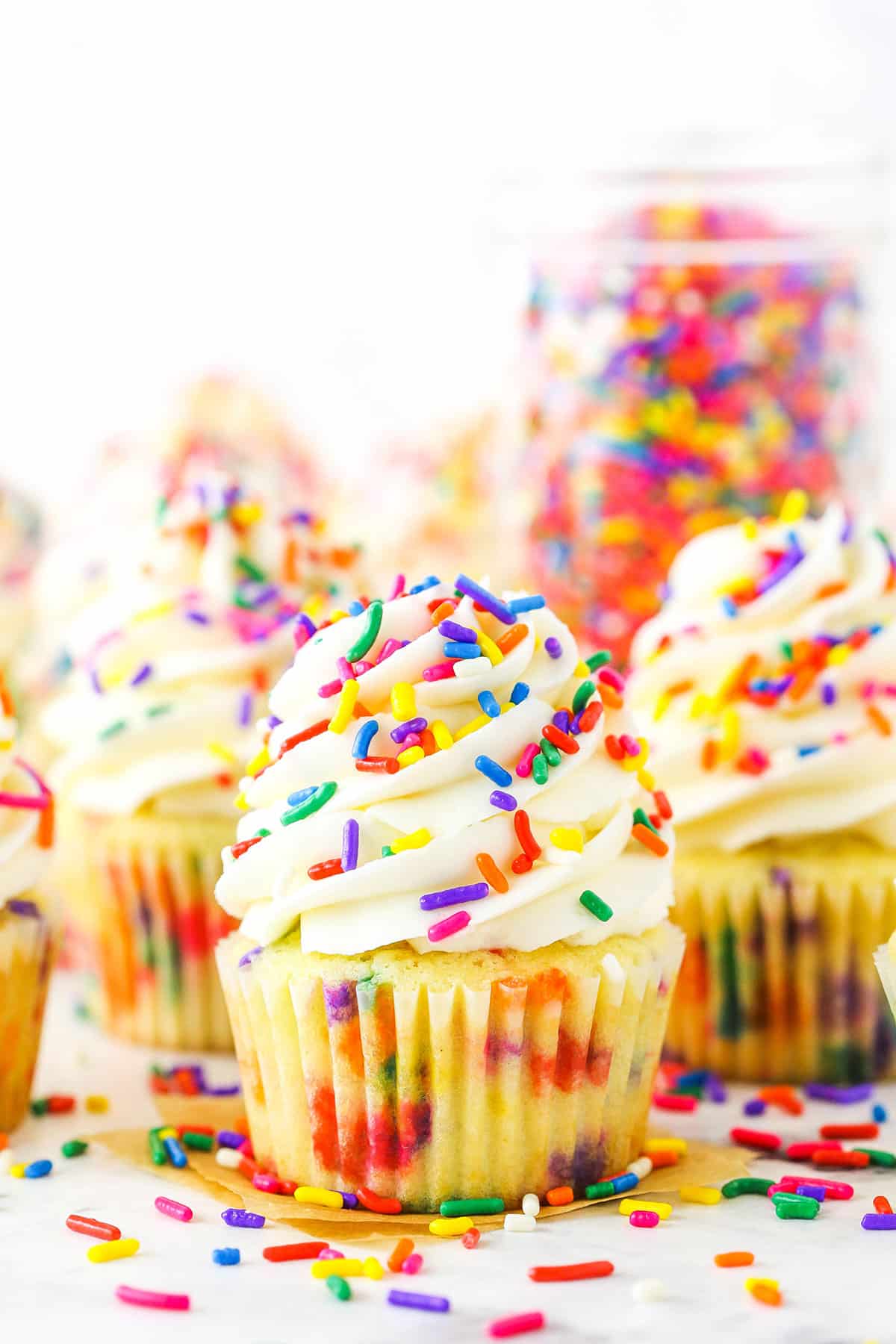 Homemade Funfetti Cupcakes topped with white frosting and colorful sprinkles