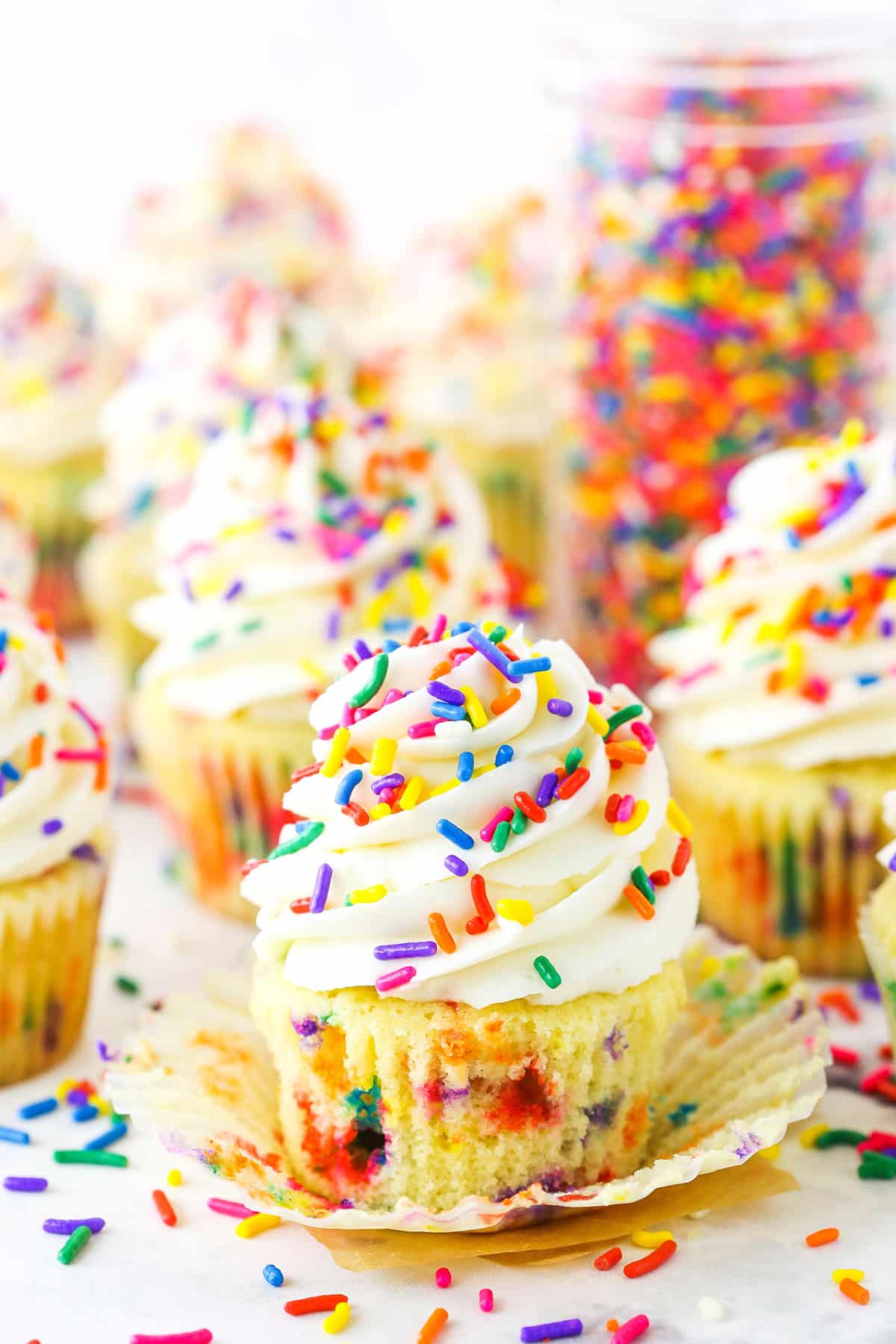 Homemade Funfetti Cupcakes topped with white frosting and colorful sprinkles