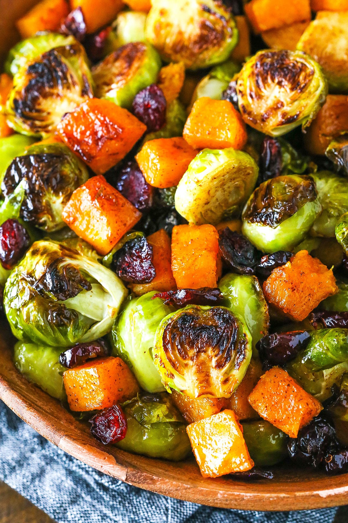 Honey Roasted Brussels Sprouts with Butternut Squash and Cranberries in a wooden serving dish