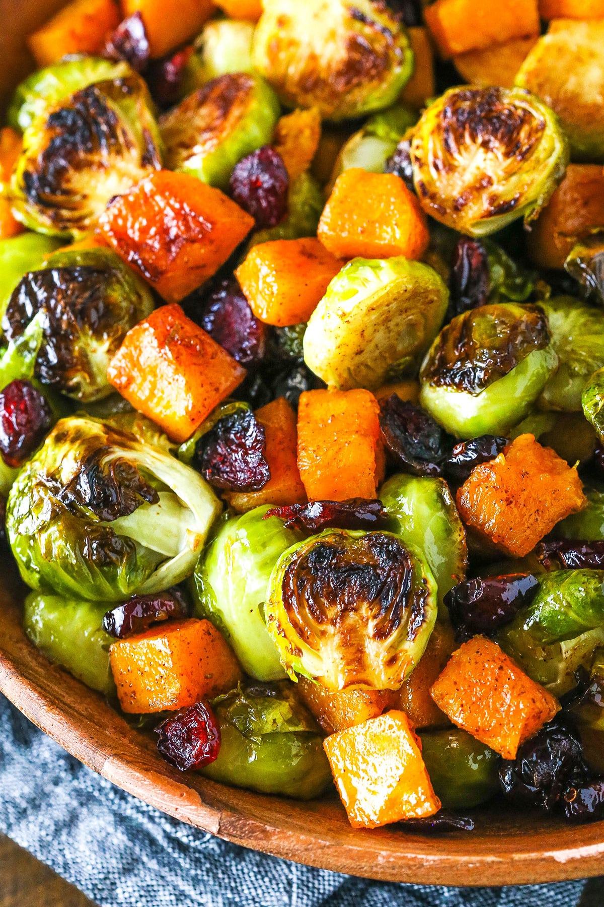 Honey Roasted Brussels Sprouts with Butternut Squash and Cranberries in a wooden serving dish