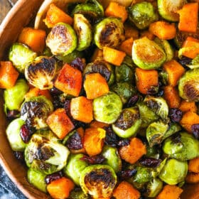 A bowl of freshly roasted Brussels sprouts with butternut squash and cranberries.