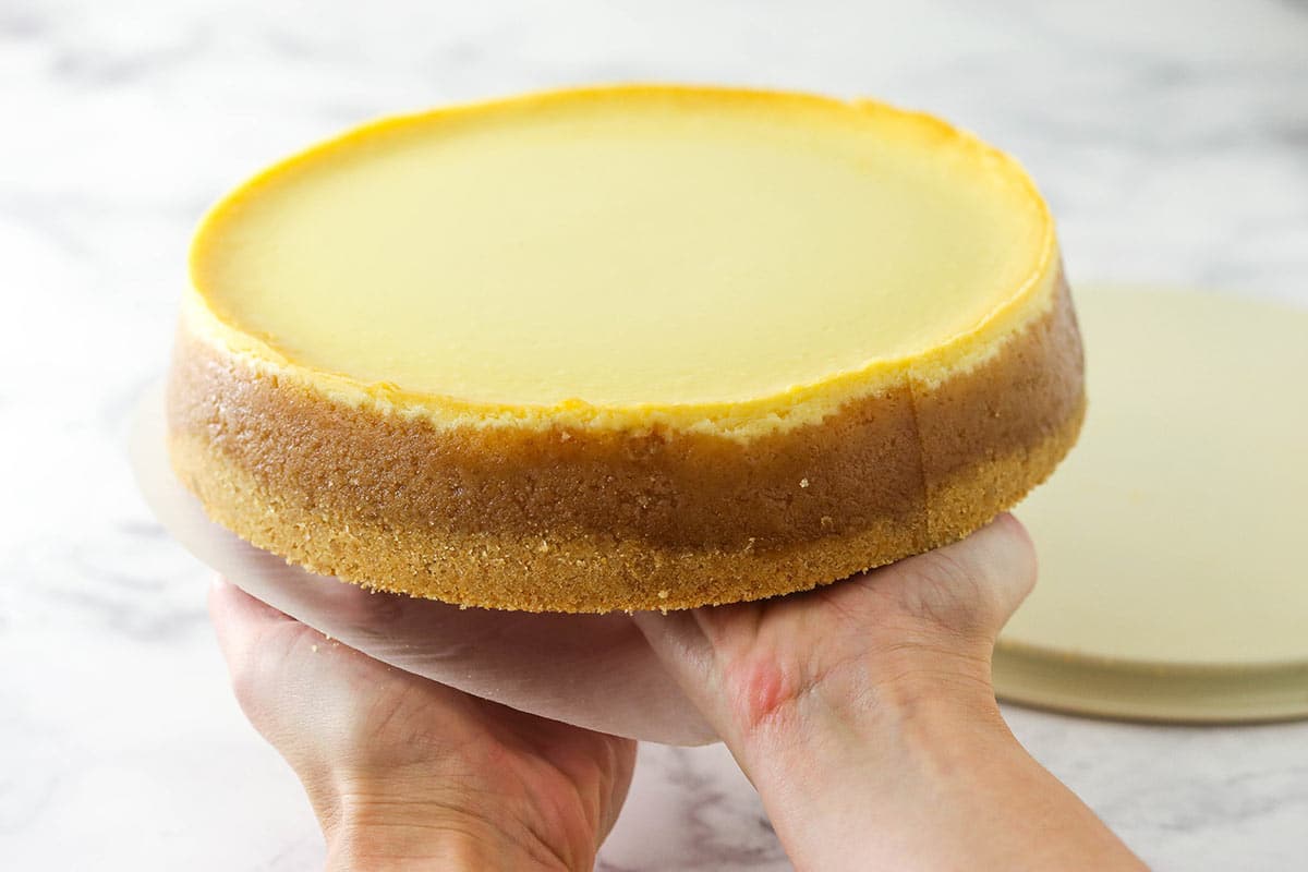 removing the parchment paper and transferring the cheesecake from my left hand to my right hand
