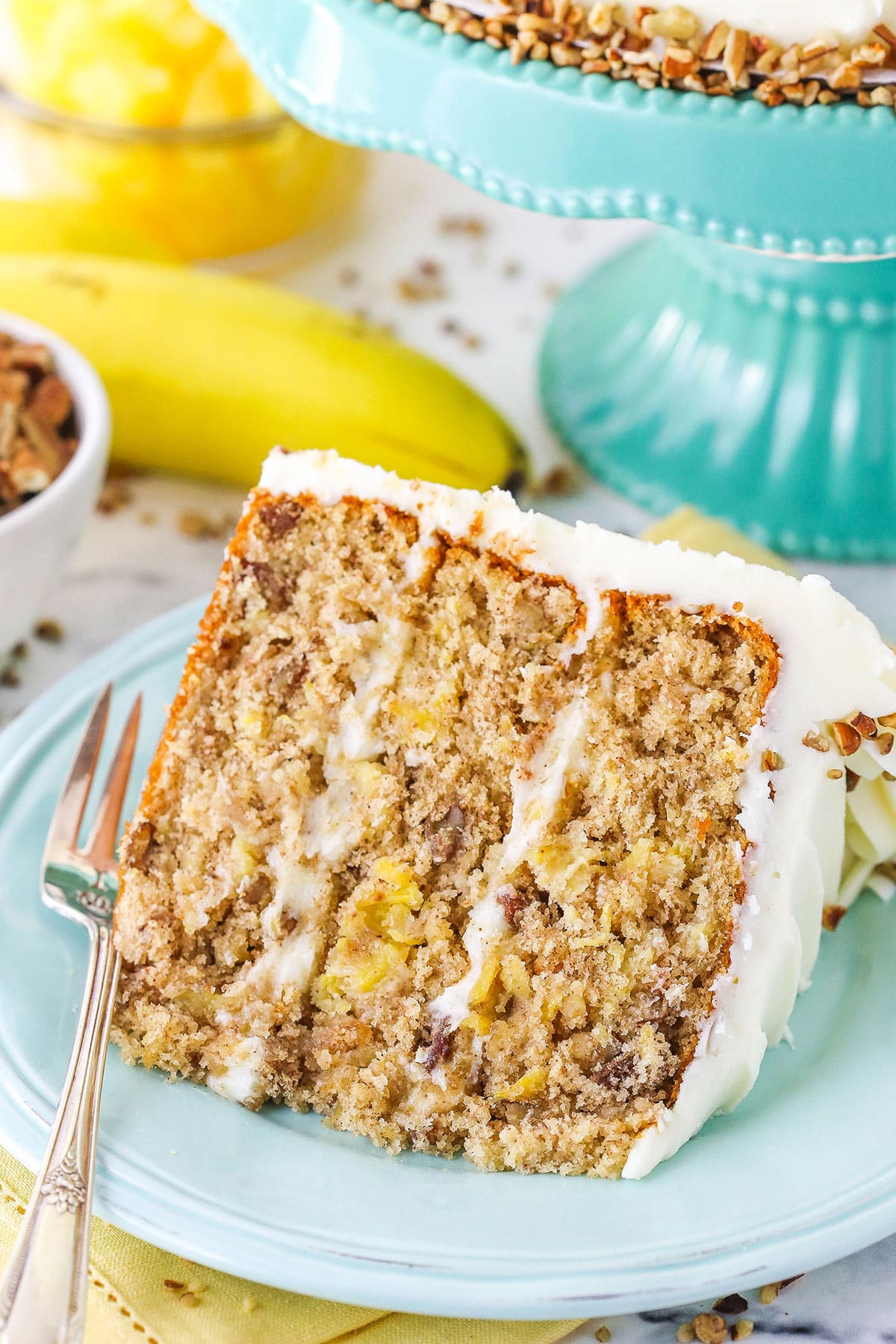 A slice of Hummingbird Cake with a fork on a blue plate