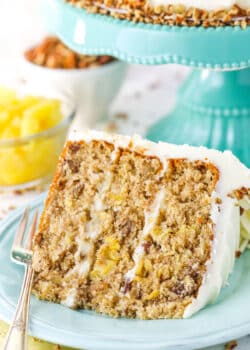 A slice of Hummingbird Cake with a fork on a blue plate