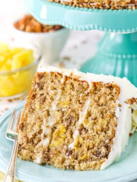 A slice of Hummingbird Cake with a fork on a blue plate