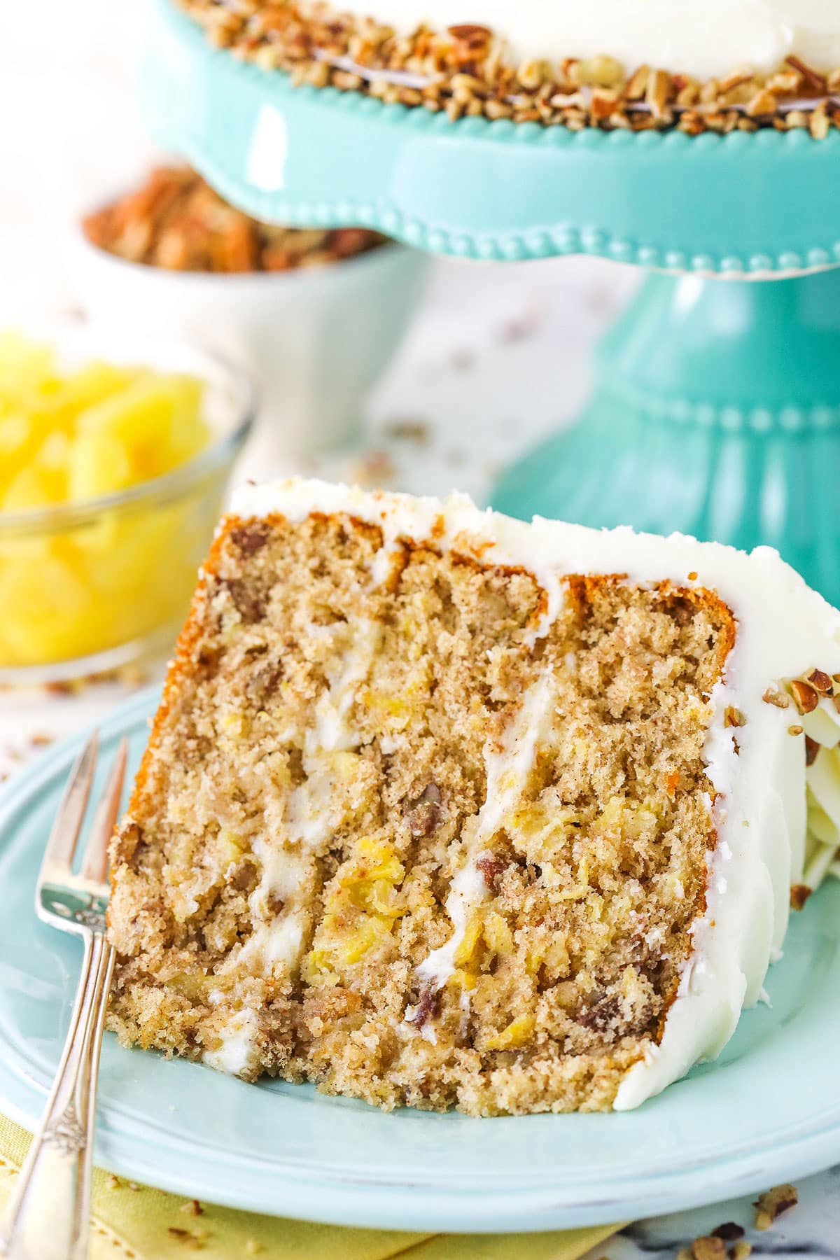 A slice of Hummingbird Cake with a fork on a blue plate
