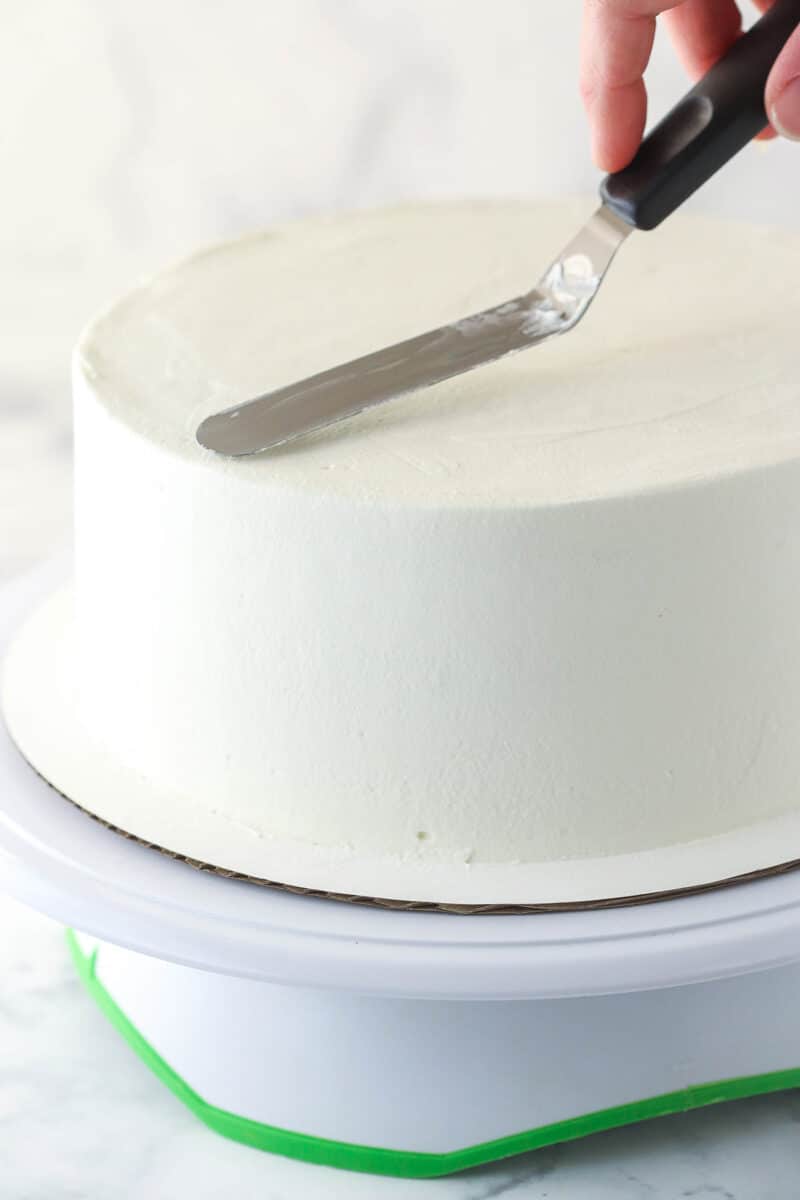 Frosting cake with whipped cream frosting.