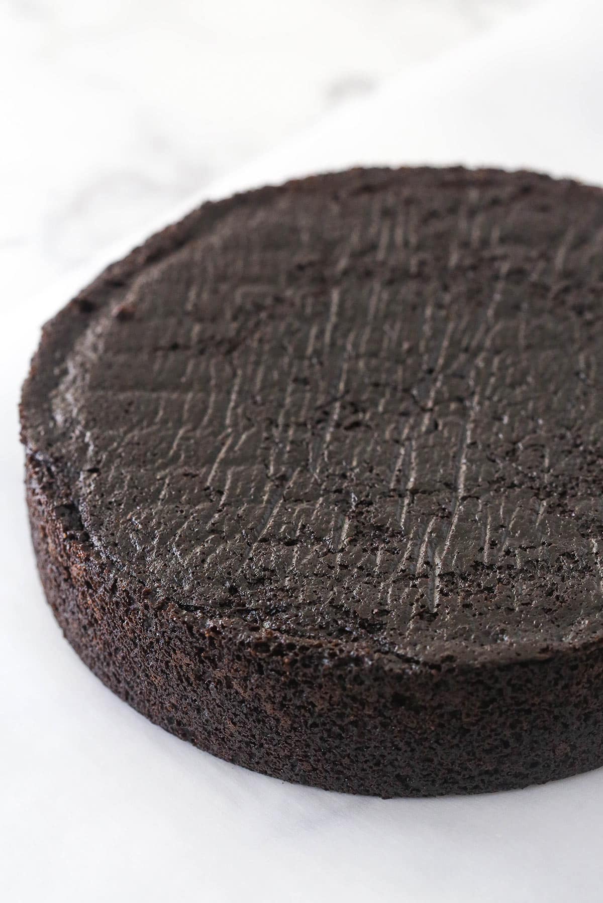 Chocolate cake, ice cream, fudgy chocolate, cookie crunchies, and a rich chocolate ganache make up this decadent ice cream cake. Baked chocolate cake layer.