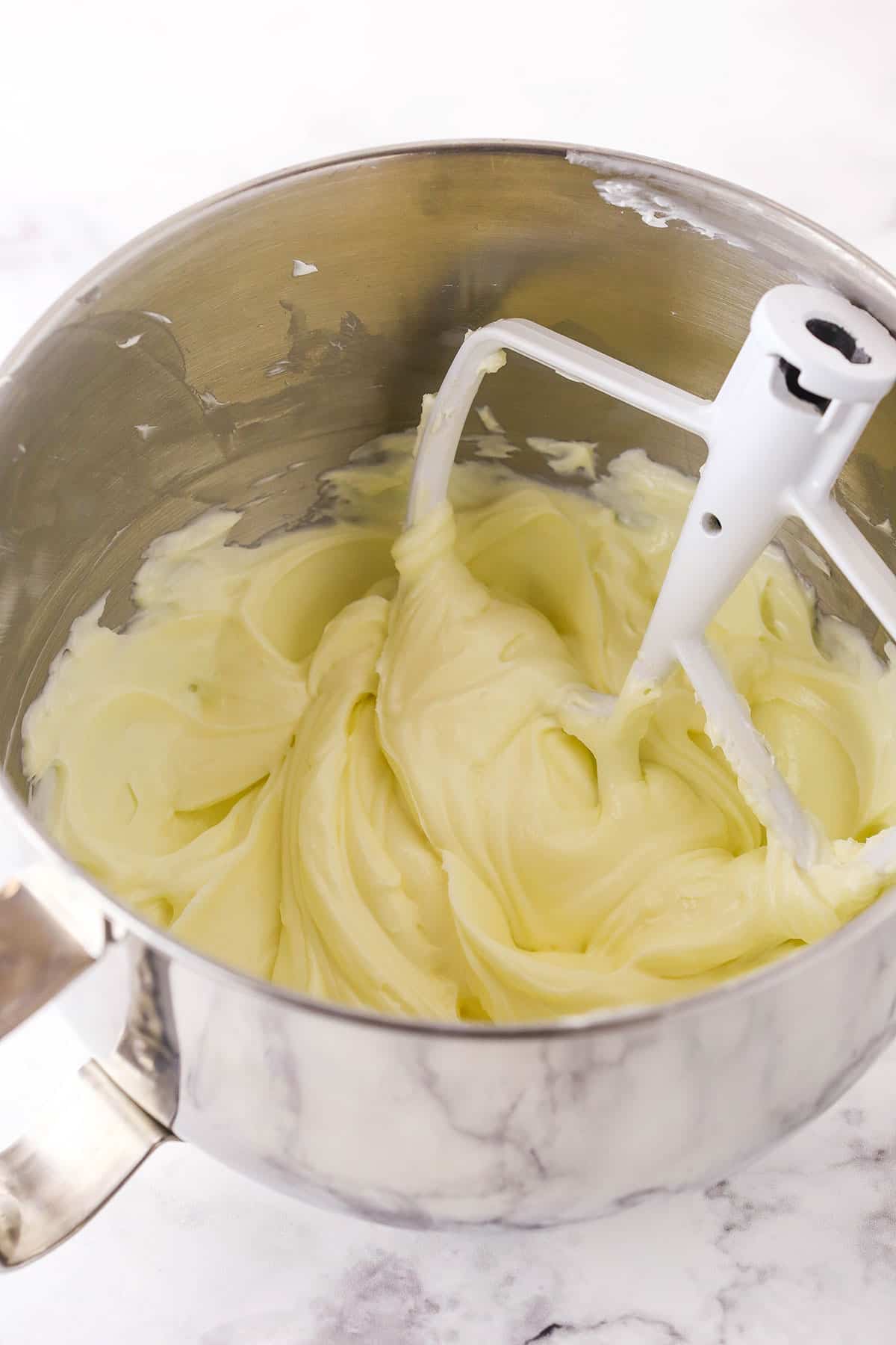 A step in making No Bake Cherry Almond Cheesecake showing making the filling by combining the ingredients in a large mixing bowl and mixing together