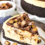 A slice of No Bake Reese's Peanut Butter Cheesecake with a fork on a white and grey plate