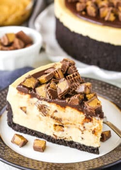 A slice of No Bake Reese's Peanut Butter Cheesecake with a fork on a white and grey plate.