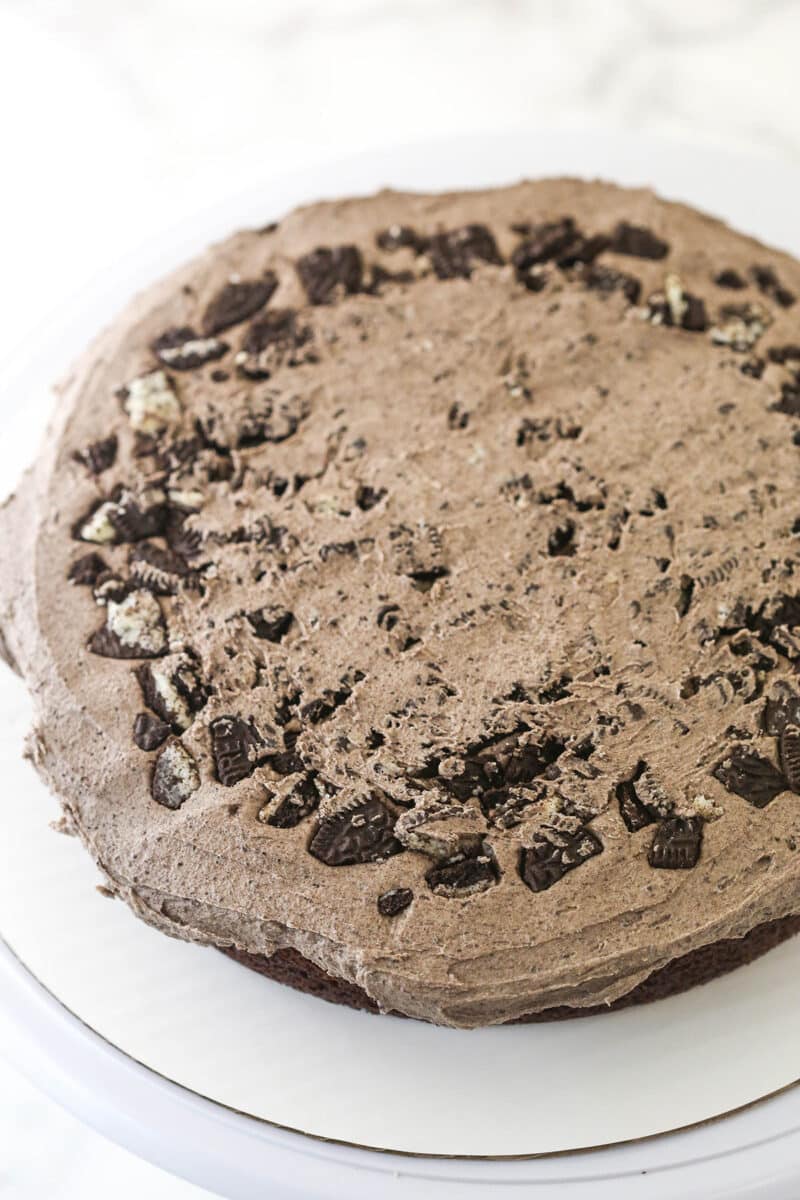 Oreo buttercream frosting spread over the top of chocolate cake.