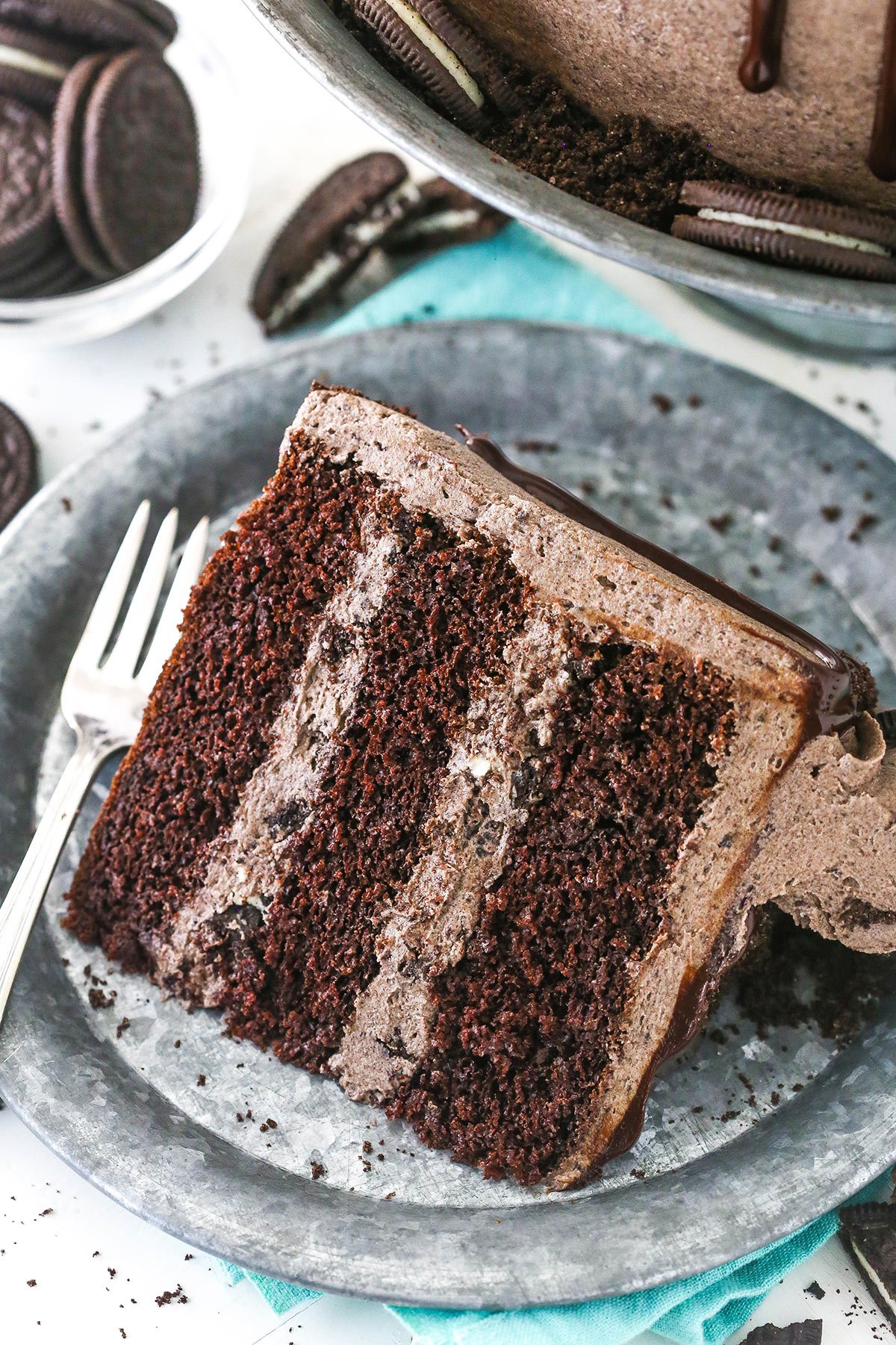 A slice of chocolate Oreo cake on a plate with a fork.