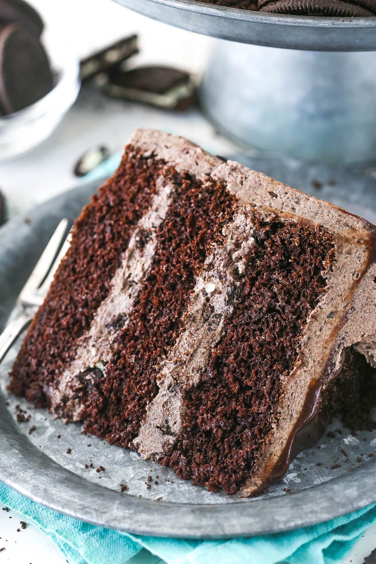 A slice of chocolate Oreo cake on a plate.