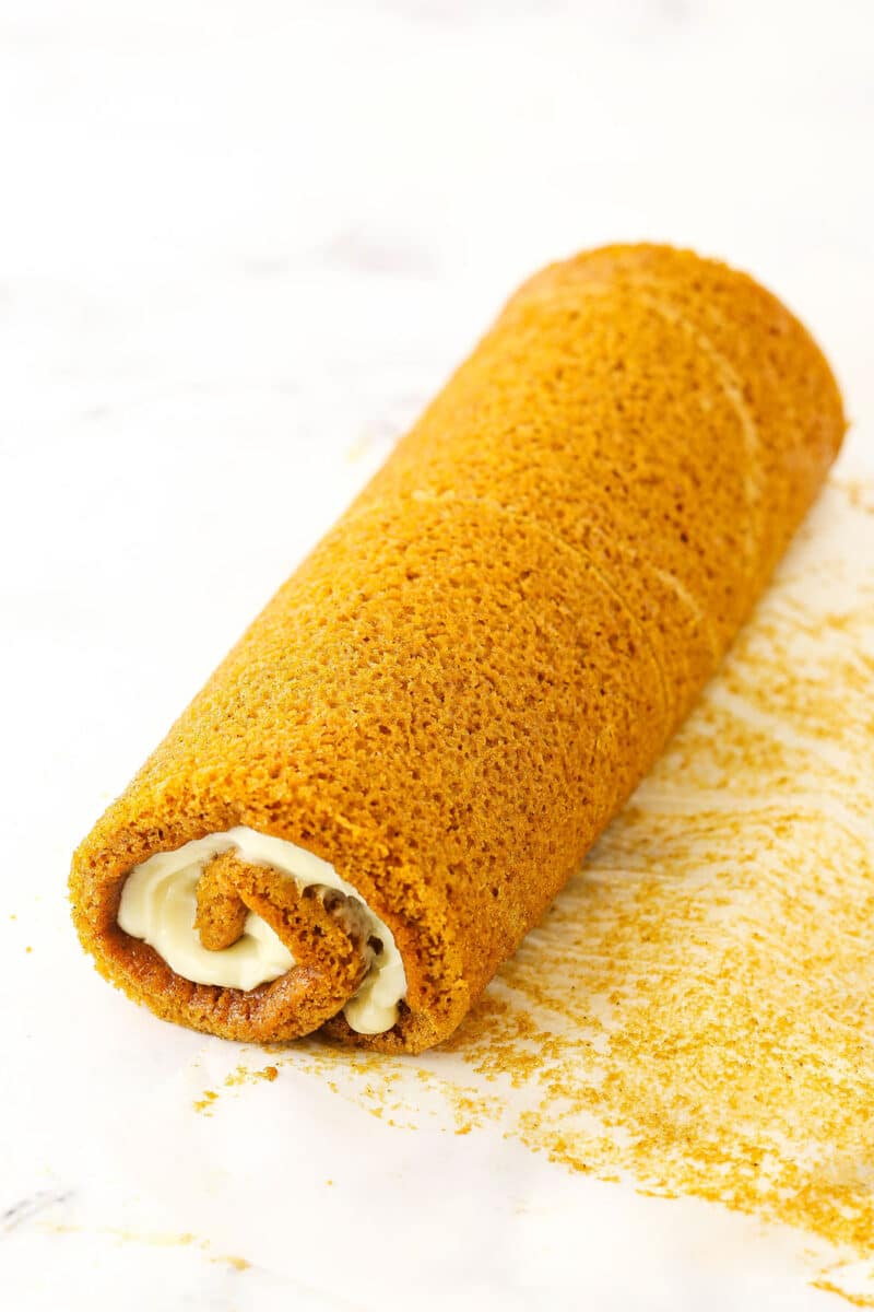 A step in making Pumpkin Roll Cake showing the cake rolled after the filling was added.
