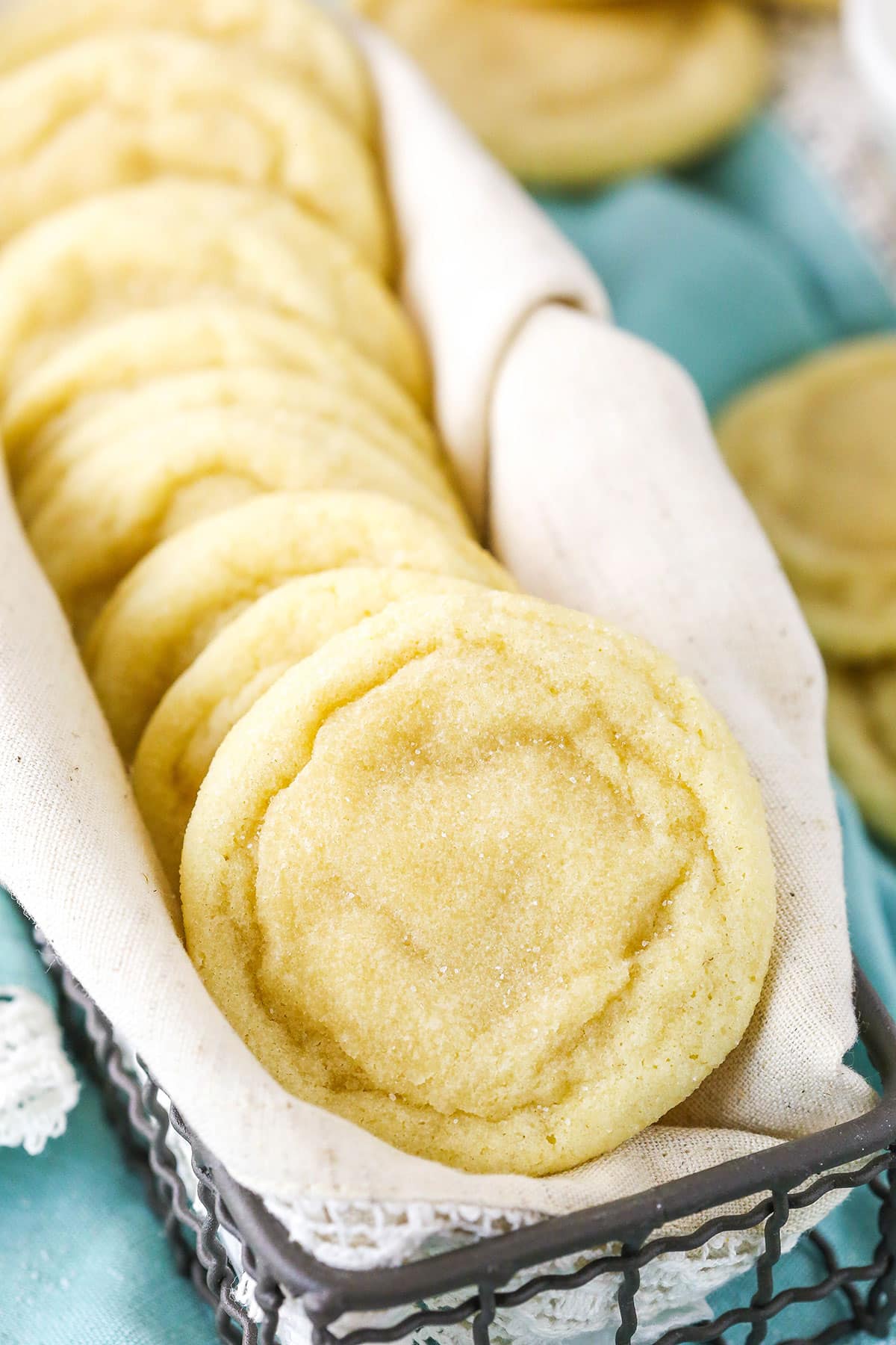 This easy sugar cookie recipe requires NO CHILLING and makes soft sugar cookies that stay chewy for DAYS! My best sugar cookies! Sugar Cookies stacked sideways in a metal serving basket
