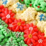 Red flower, white snowflake and green Christmas tree Spritz Cookies layered in a white cookie platter