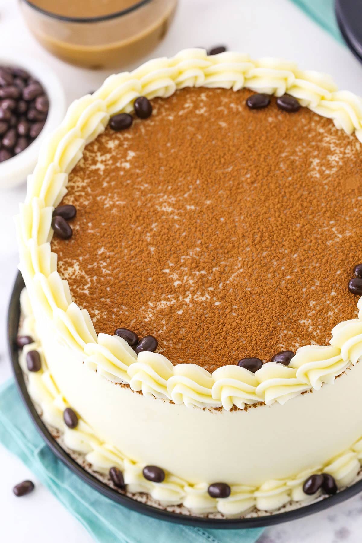 Overhead view of a full Tiramisu Layer Cake on a black plate