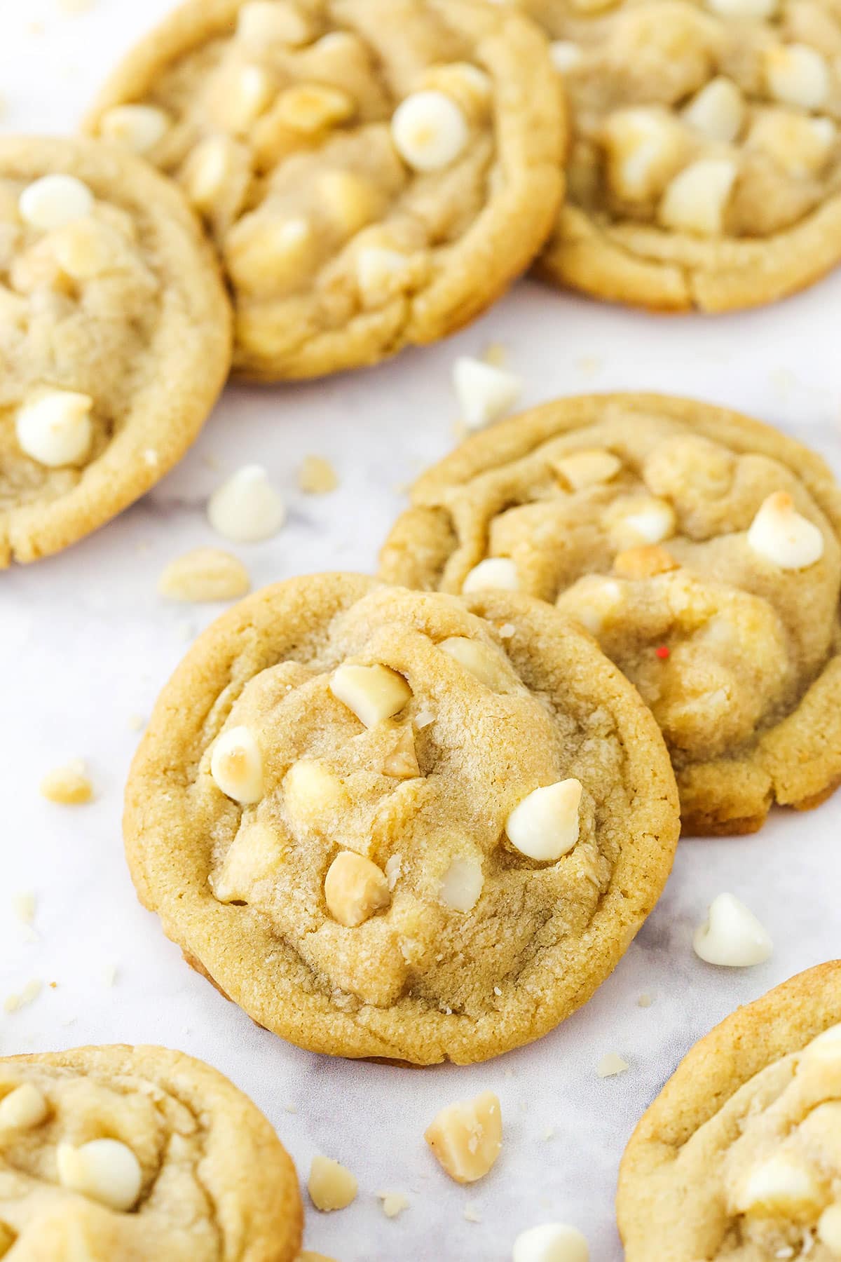 White Chocolate Macadamia Nut Cookies spread over a white marble tabletop