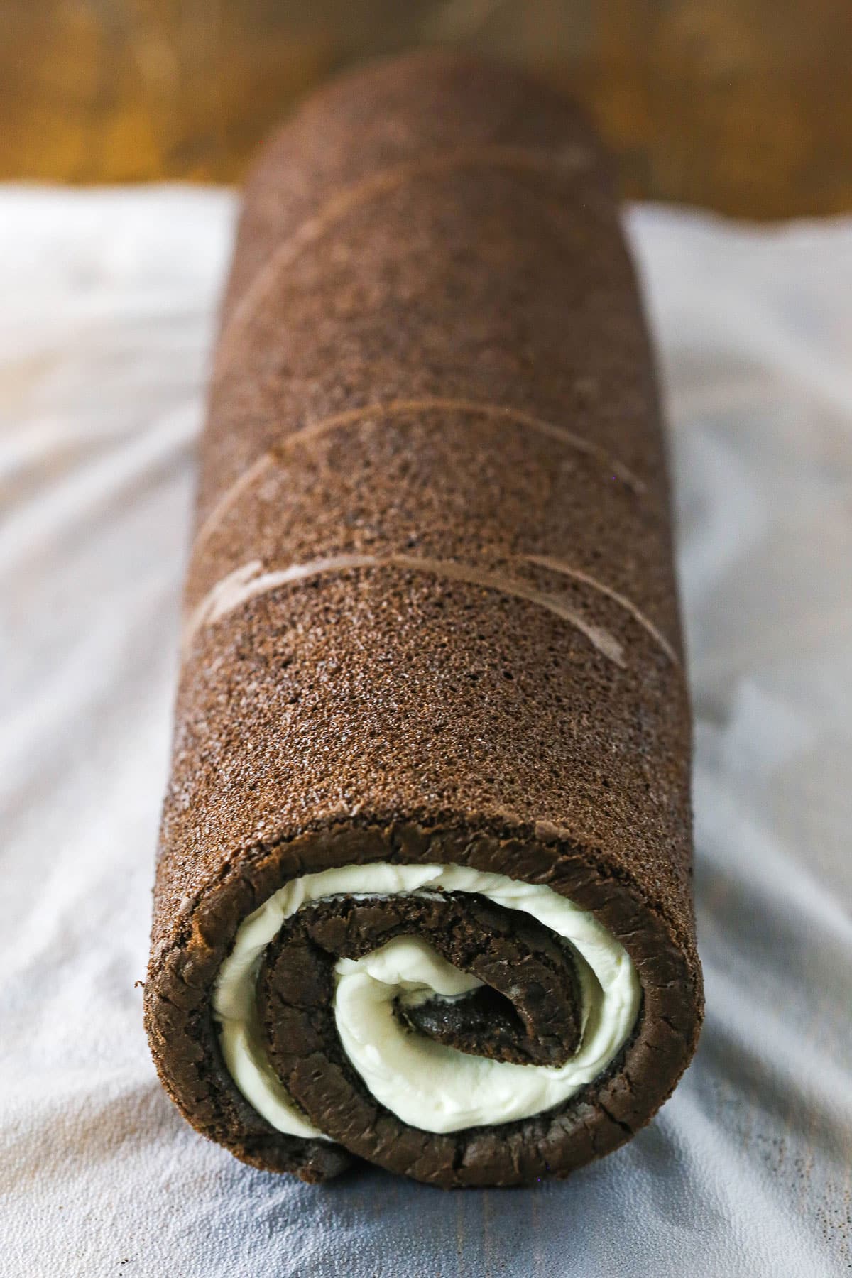 A step in making a Yule Log Cake showing the rolled cake after the filling was added