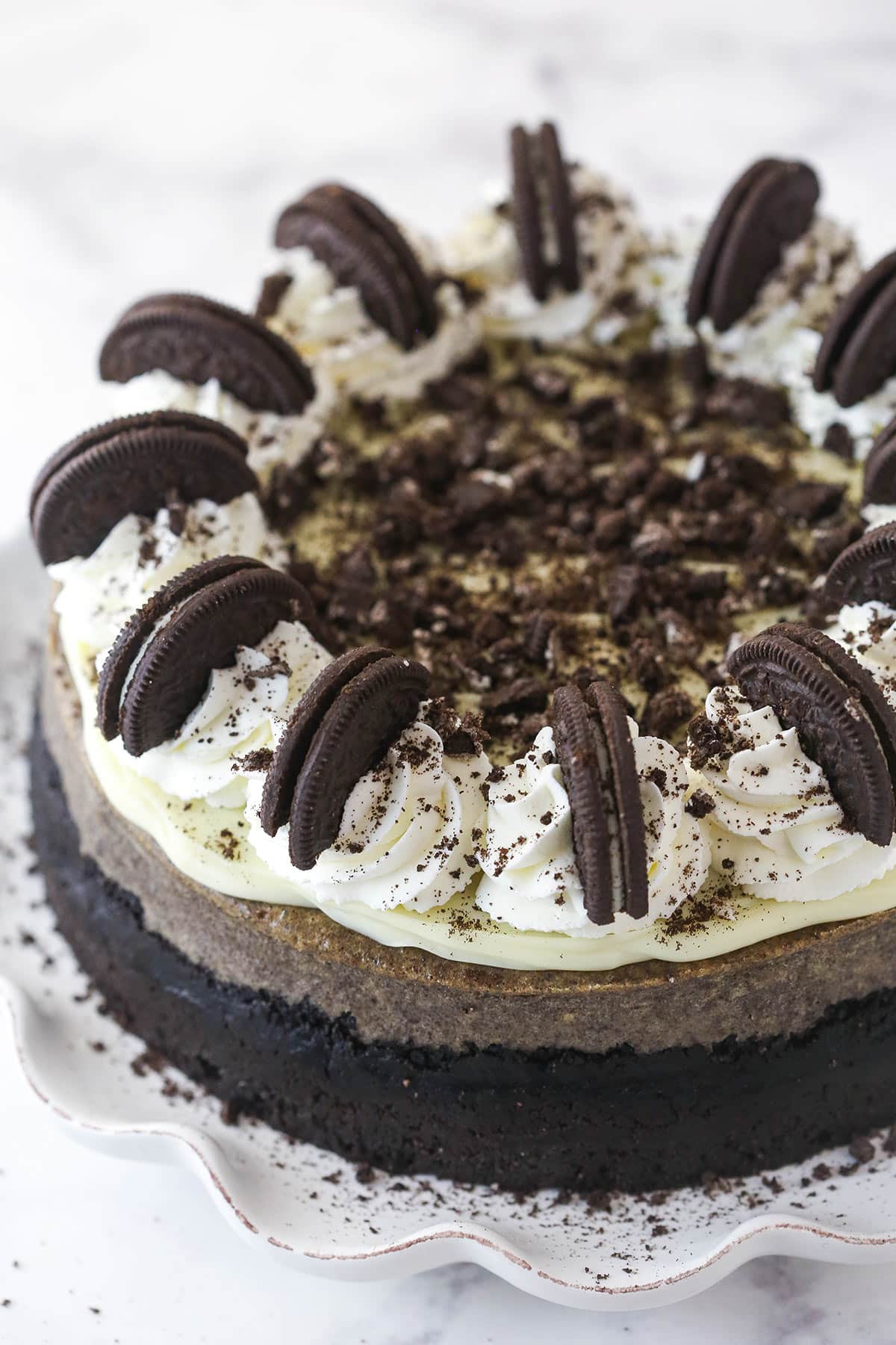 The Best Oreo cheesecake on a cake platter.