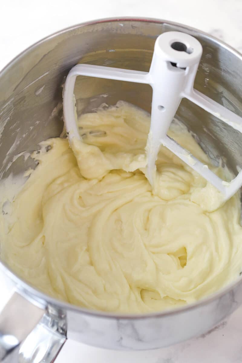 Beating together cream cheese, sugar, and flour for cheesecake.