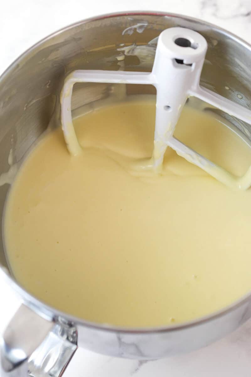 Adding eggs to cheesecake batter.