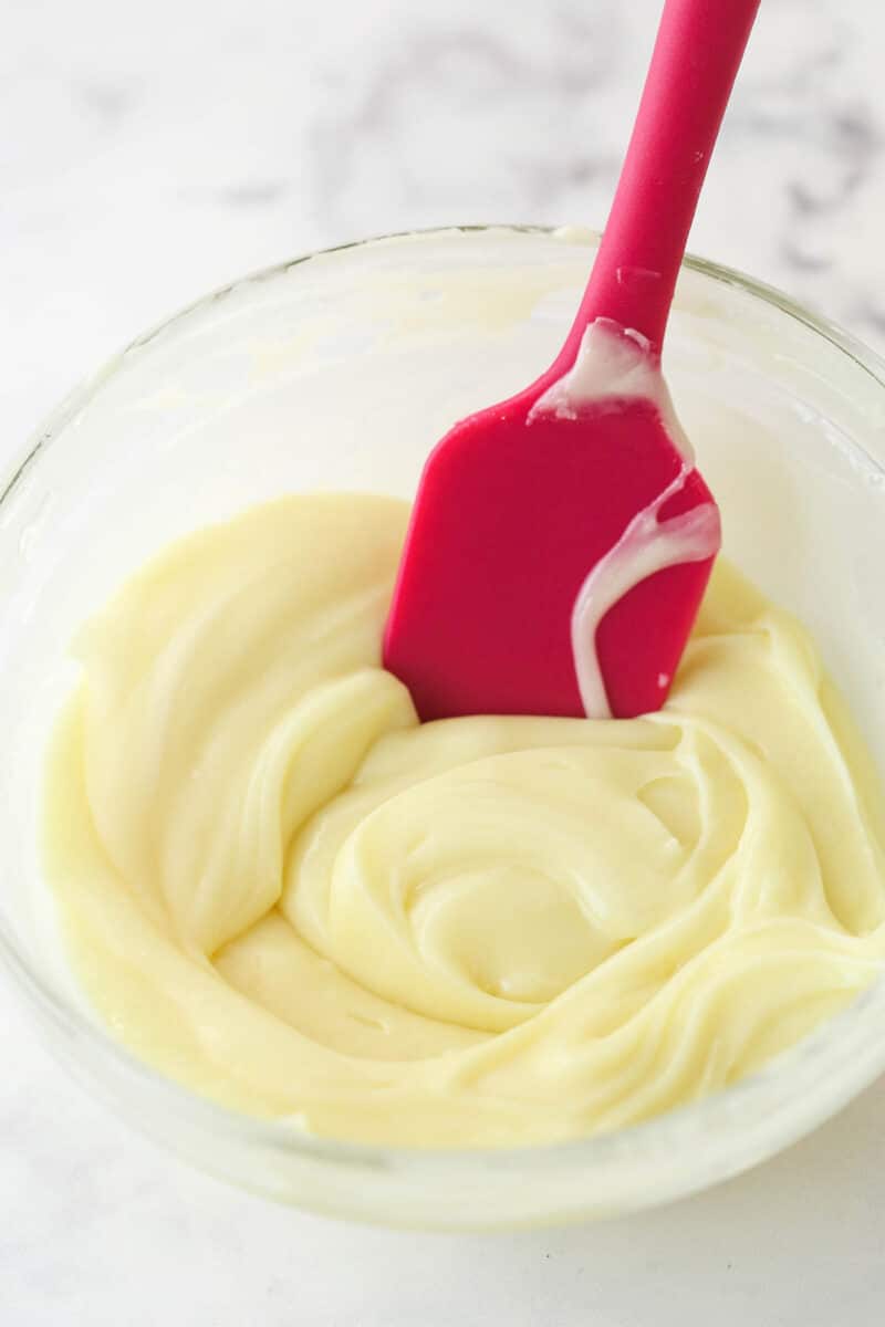 Mixing white chocolate ganache with a rubber spatula.