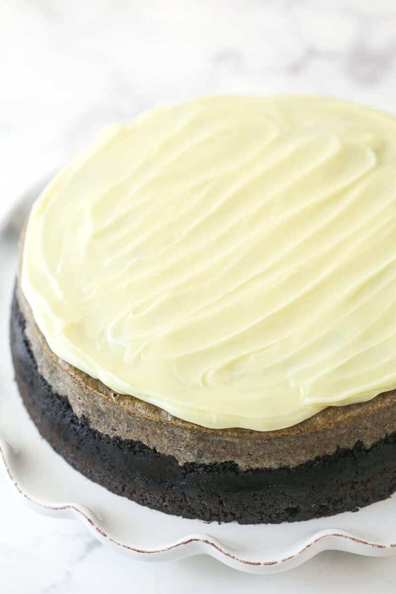 Topping Oreo cheesecake with white chocolate ganache.