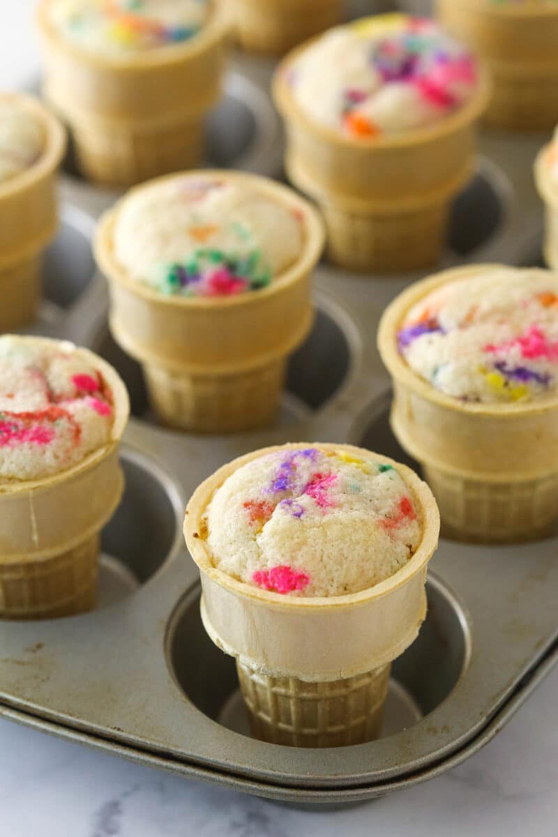 Baked ice cream cone cupcakes cooling in a cupcake pan.