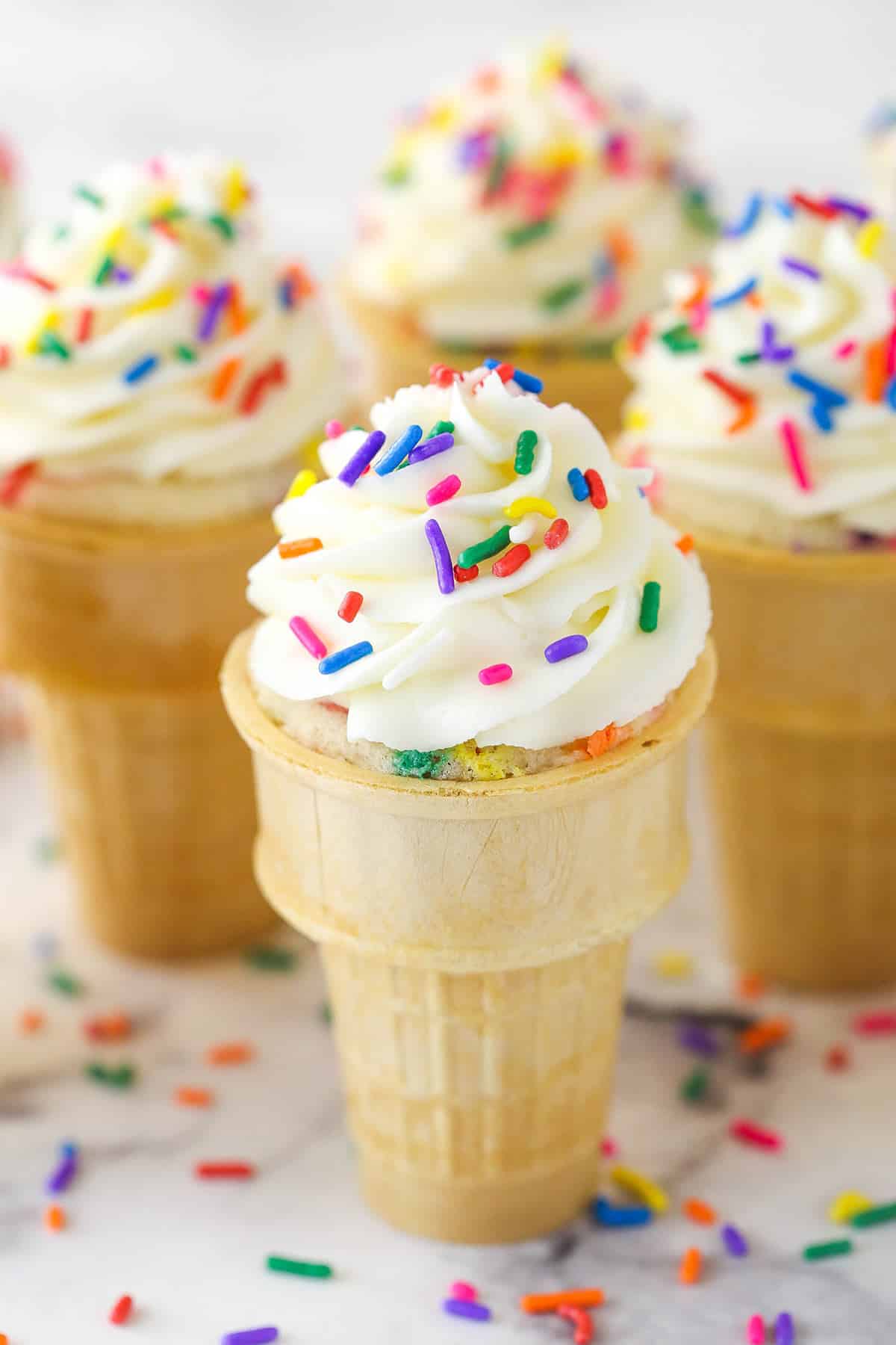 Closeup of ice cream cone cupcakes on a marble surface.