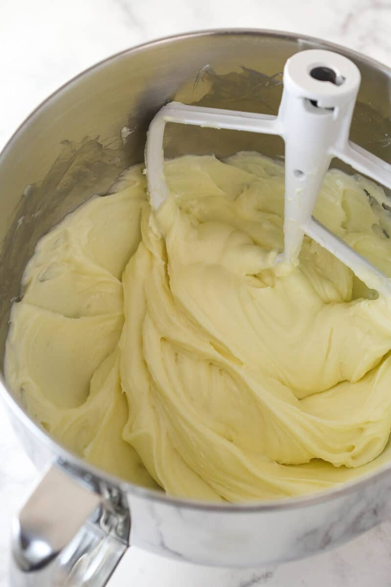 Beating together cream cheese, sugar and flour for cheesecake.