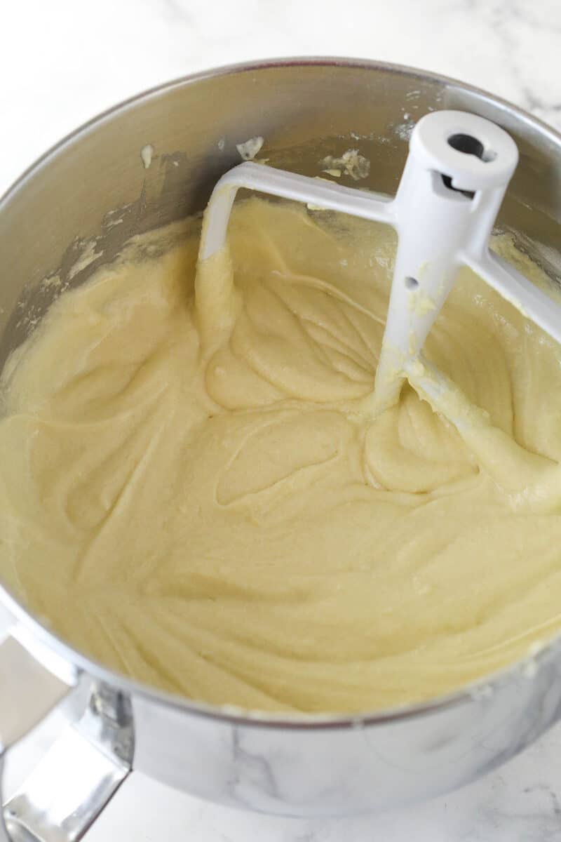 Adding dry ingredients and milk to vanilla cake batter.