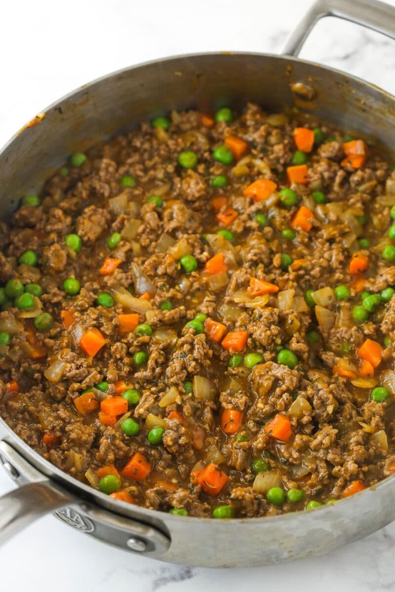 This easy Sheperd's Pie is made of perfectly seasoned ground beef and veggies topped with mashed potatoes and cheese and baked to bubbly. Shepherd's pie filling in a pan.