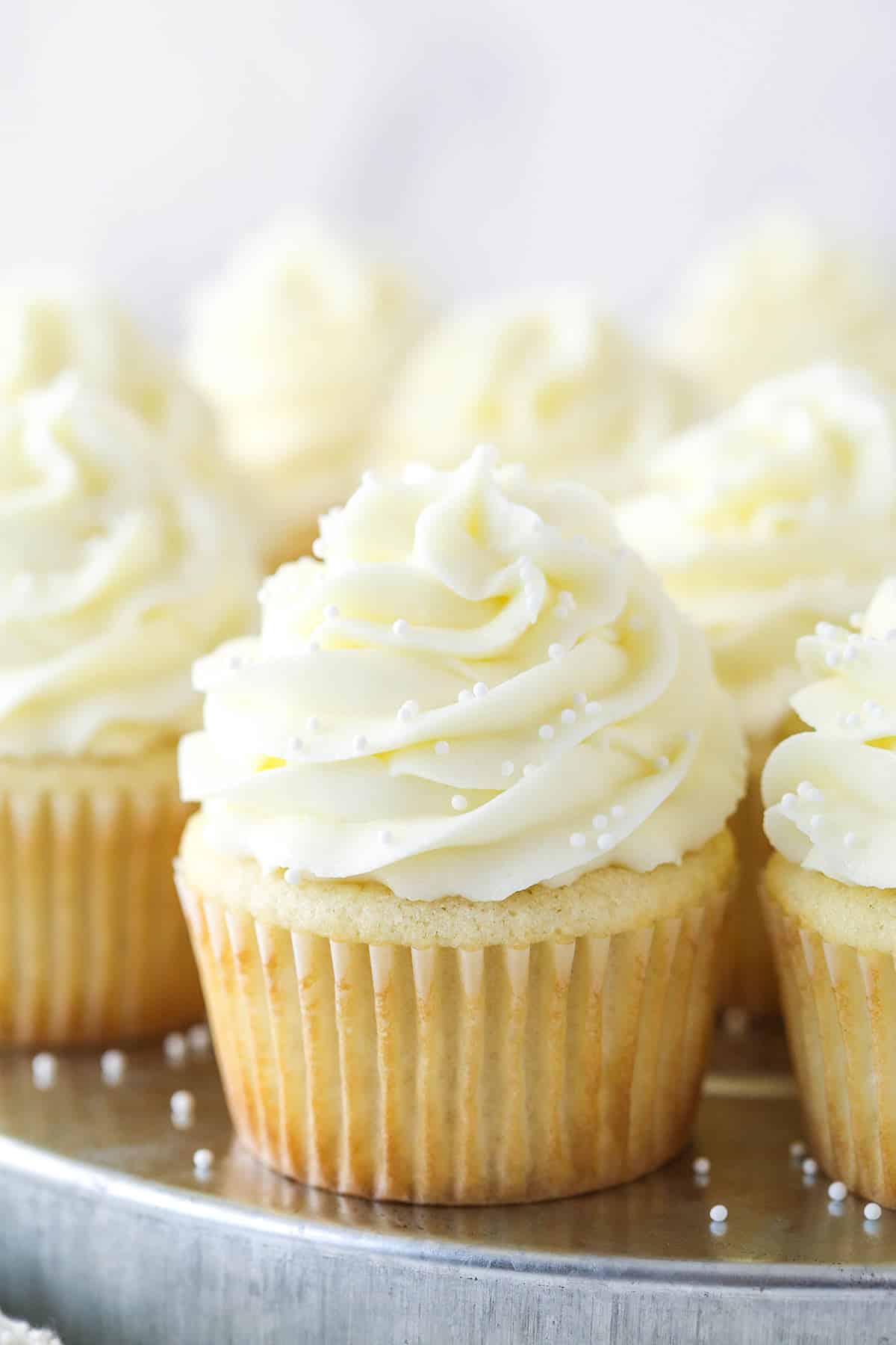 Closeup of white cupcakes on a serving tray.