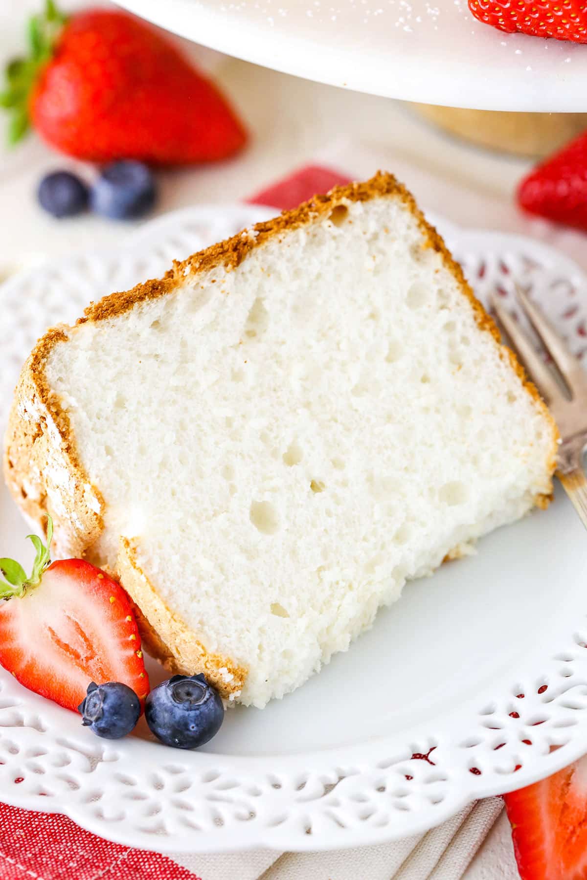 A slice of angel food cake on a plate with fresh berries.