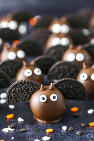 Bat Oreo Cookie Balls with Oreo wings spread out on a black table top