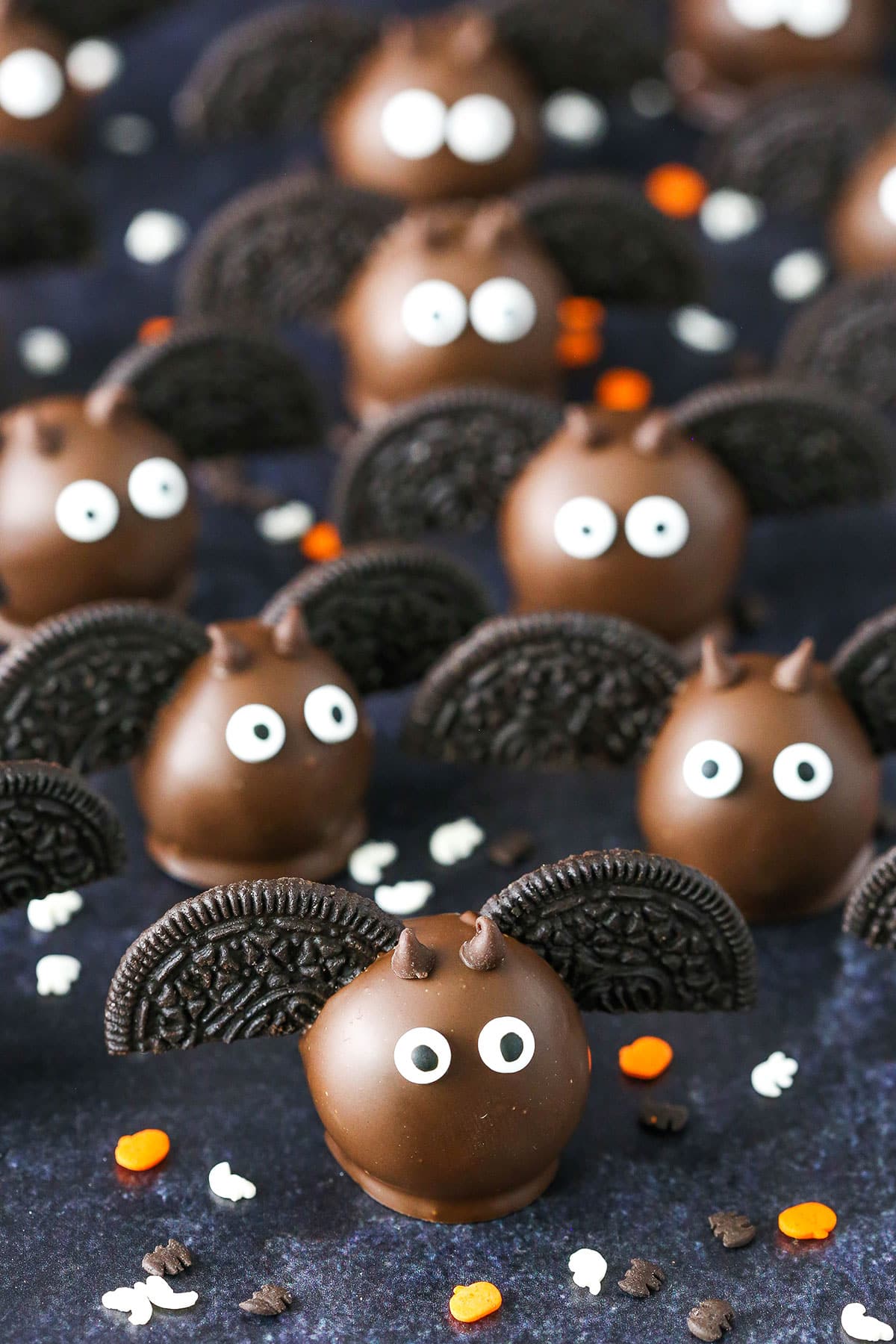 Bat Oreo Cookie Balls with Oreo wings spread out on a black table top