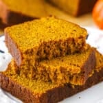 Two halves of Pumpkin Bread on top of another slice of Pumpkin Bread on a white plate