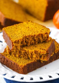 Two halves of Pumpkin Bread on top of another slice of Pumpkin Bread on a white plate