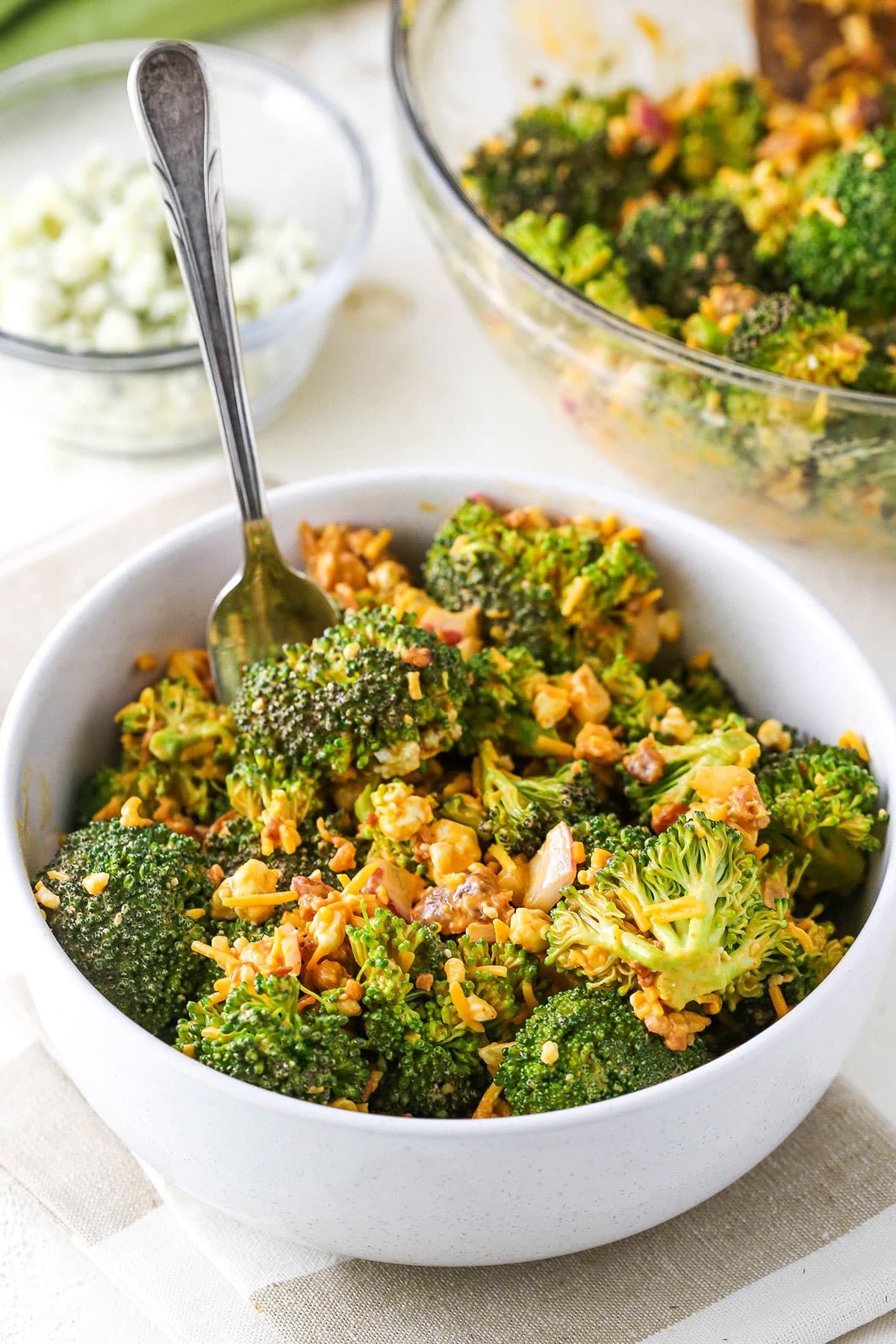 A serving of Buffalo Broccoli Salad with a fork in a white bowl