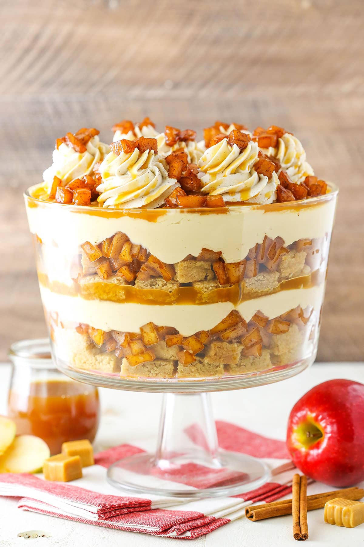 Side view of a full Caramel Apple Cheesecake Blondie Trifle in a glass trifle stand