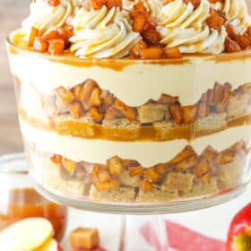 Side view of a full Caramel Apple Cheesecake Blondie Trifle in a glass trifle stand