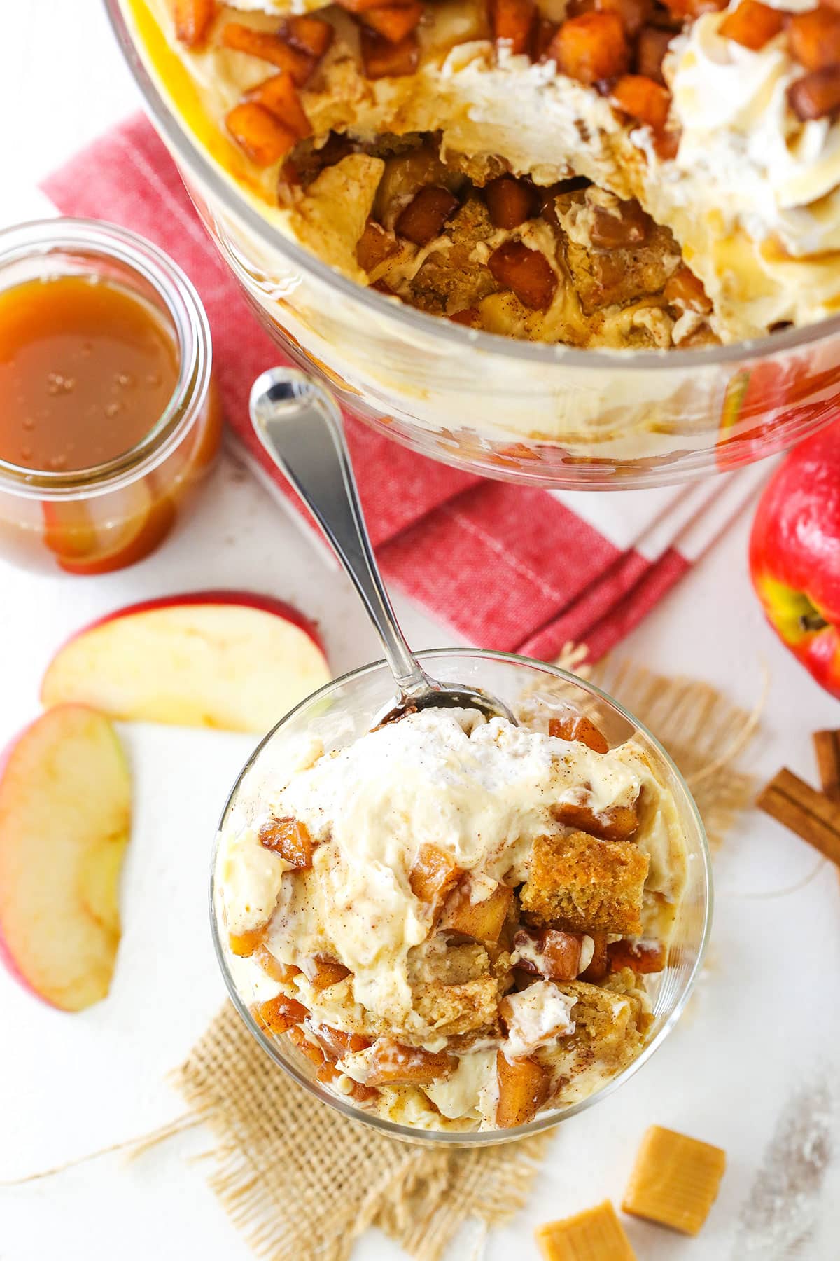 Overhead view of a serving of Caramel Apple Cheesecake Blondie Trifle in a glass bowl with a spoon