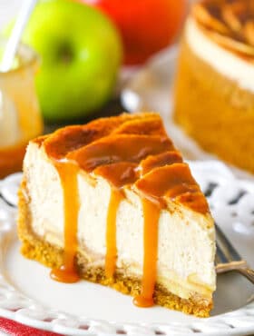 A slice of Caramel Apple Cheesecake next to a fork on a white plate